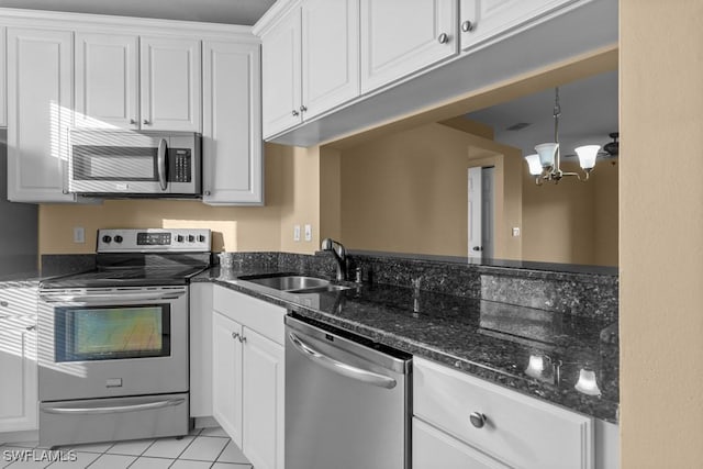 kitchen with white cabinets, sink, light tile patterned flooring, stainless steel appliances, and a chandelier