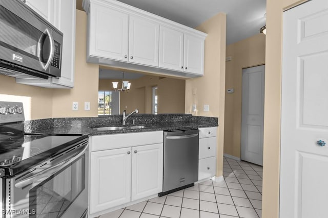 kitchen featuring stainless steel appliances, white cabinetry, and light tile patterned flooring