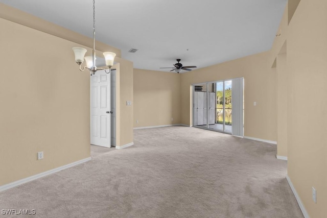 empty room with ceiling fan with notable chandelier and light carpet