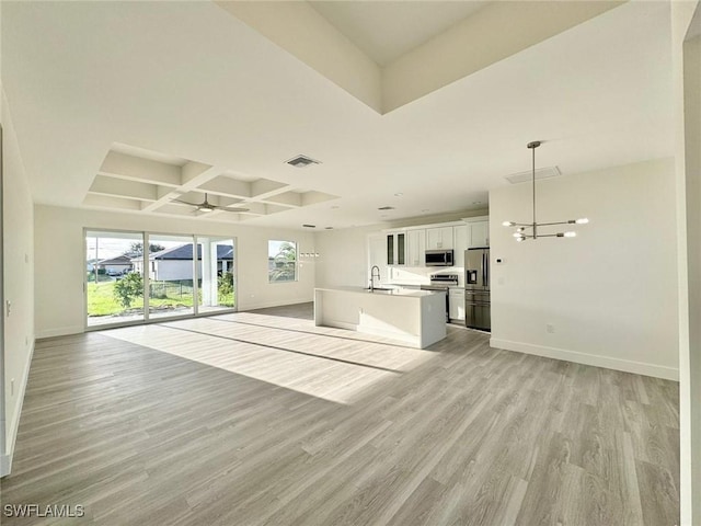 unfurnished living room with coffered ceiling, ceiling fan with notable chandelier, sink, beam ceiling, and light hardwood / wood-style floors