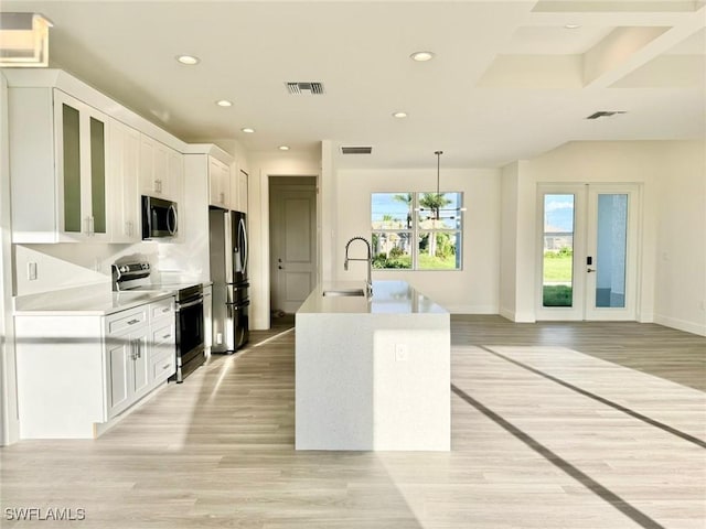 kitchen featuring appliances with stainless steel finishes, light wood-type flooring, sink, decorative light fixtures, and white cabinets