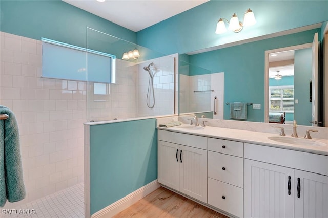 bathroom with a tile shower, vanity, and hardwood / wood-style flooring