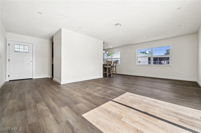 unfurnished living room featuring hardwood / wood-style flooring and a notable chandelier