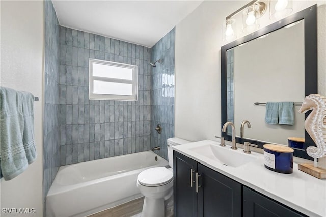 full bathroom with vanity, wood-type flooring, tiled shower / bath combo, and toilet