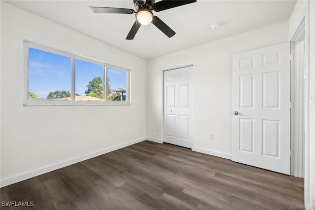 unfurnished bedroom featuring a closet, dark hardwood / wood-style floors, and ceiling fan