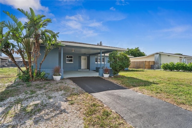 ranch-style house with a carport, central AC unit, and a front yard