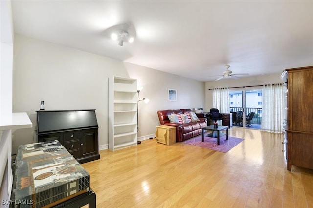 living room with ceiling fan and light hardwood / wood-style flooring