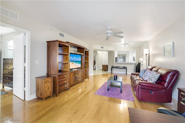 living room featuring ceiling fan and light wood-type flooring