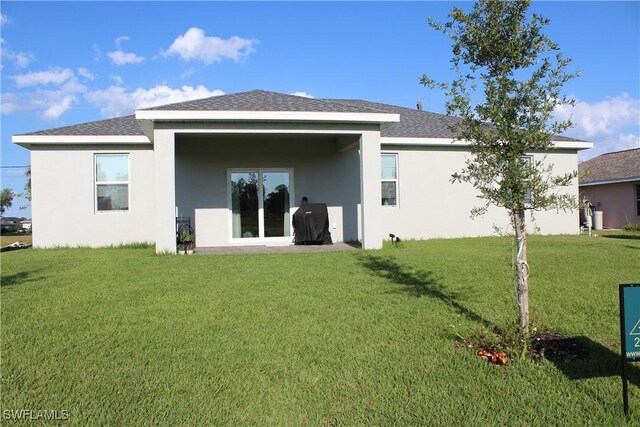 rear view of property featuring a lawn