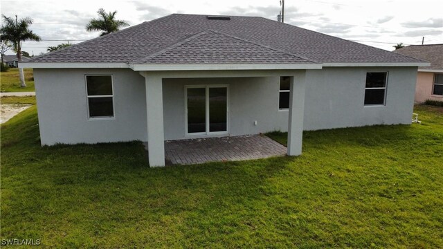 back of property with a yard and a patio