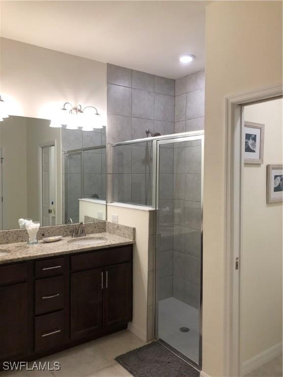 bathroom with vanity, tile patterned floors, and a shower with shower door