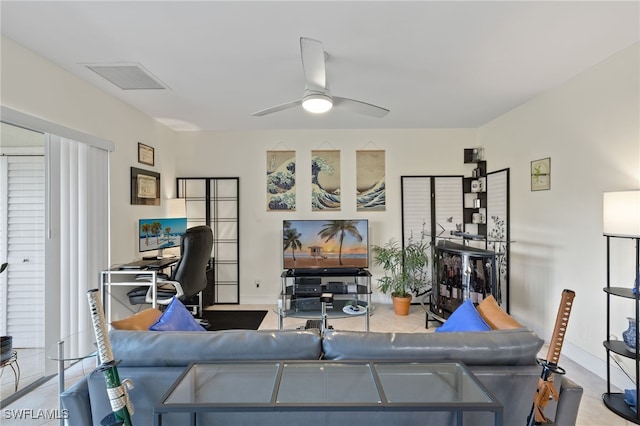 living room with baseboards, visible vents, and a ceiling fan