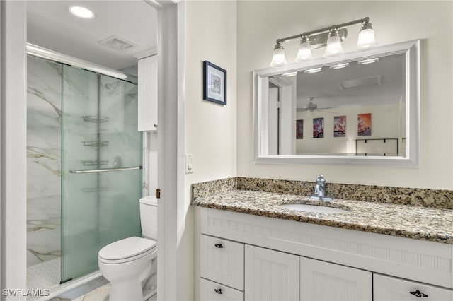 bathroom with a marble finish shower, visible vents, toilet, ceiling fan, and vanity