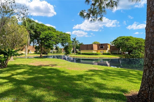 view of home's community with a water view and a yard