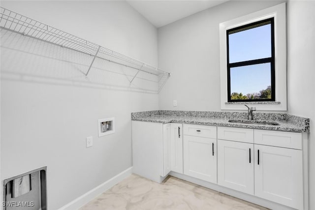 clothes washing area featuring cabinets, sink, and washer hookup