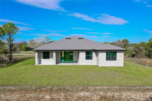 rear view of property featuring a patio area and a yard