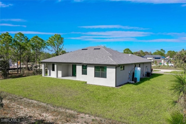 rear view of property featuring a lawn, a patio area, and central AC