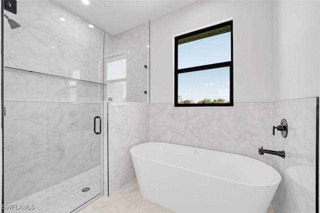 bathroom with separate shower and tub and tile walls