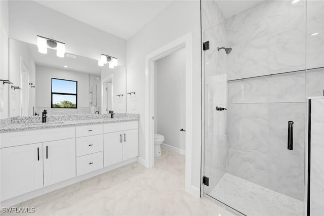 bathroom featuring a shower with door, vanity, and toilet