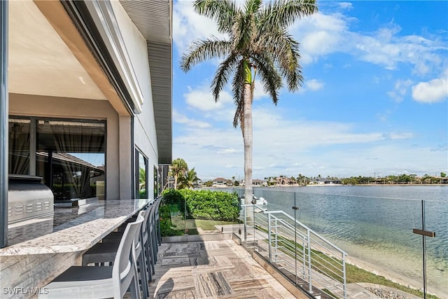 exterior space featuring a balcony and a water view