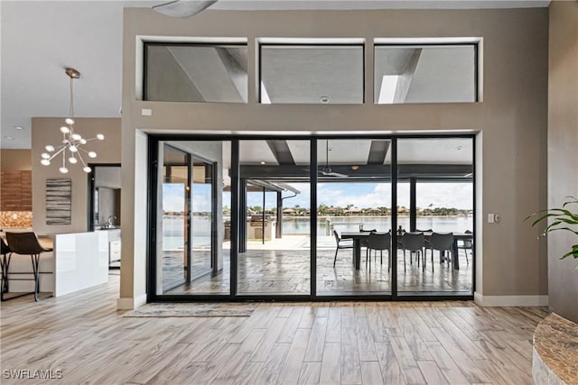 doorway with a water view and an inviting chandelier