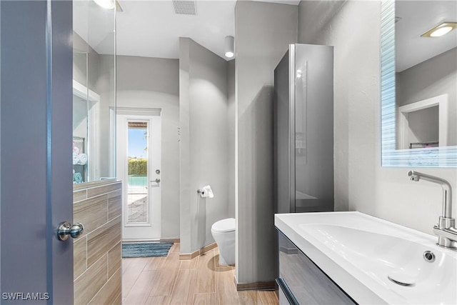 bathroom with vanity, toilet, and hardwood / wood-style flooring