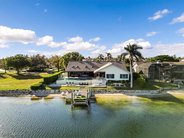 back of property featuring a patio area, a swimming pool, a lawn, and a water view