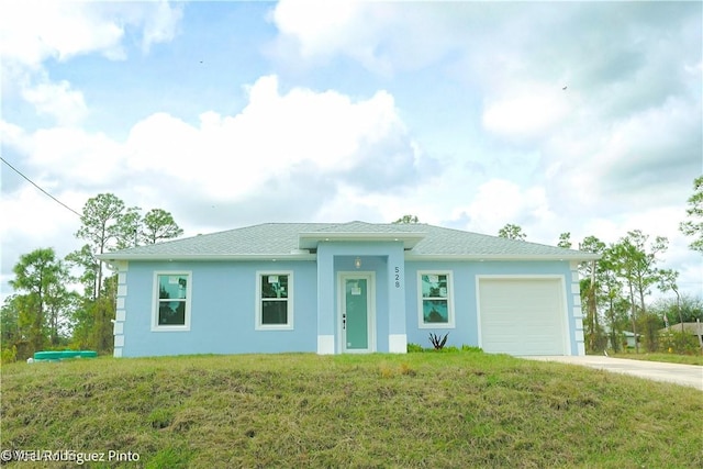 view of front of house featuring a garage and a front lawn