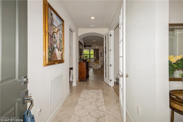 corridor featuring arched walkways, french doors, recessed lighting, visible vents, and light tile patterned flooring