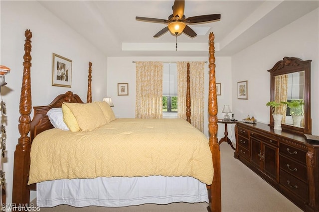 bedroom featuring carpet floors, a tray ceiling, and ceiling fan