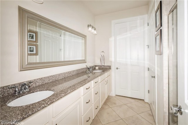 bathroom featuring double vanity, a sink, and tile patterned floors