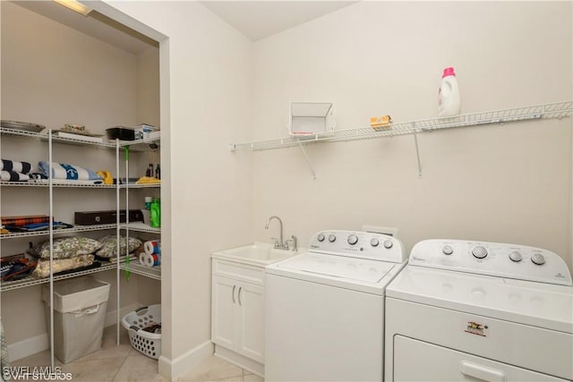 laundry area with cabinet space, light tile patterned flooring, a sink, independent washer and dryer, and baseboards