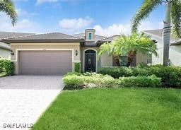 view of front of home with a garage, driveway, and a front yard