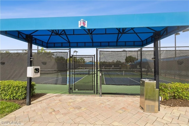 view of tennis court with a gate and fence