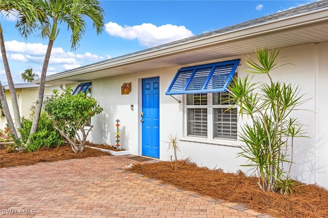 view of exterior entry with stucco siding