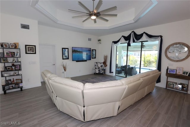 living room featuring wood-type flooring, a raised ceiling, and ceiling fan