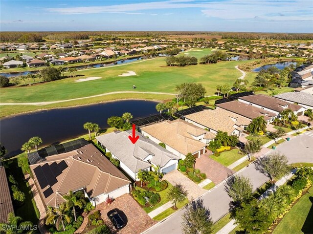 drone / aerial view with a residential view, a water view, and golf course view