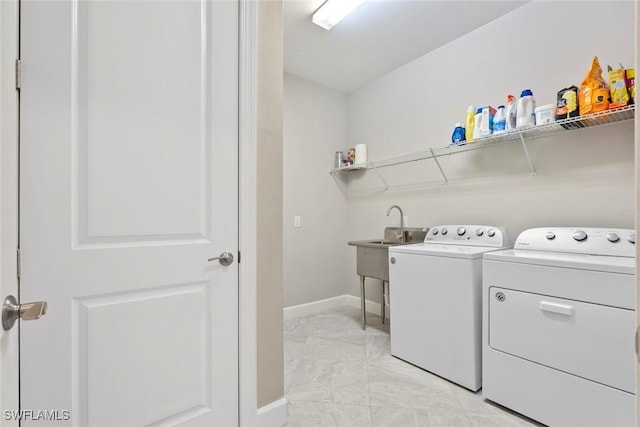 clothes washing area with washing machine and dryer and sink