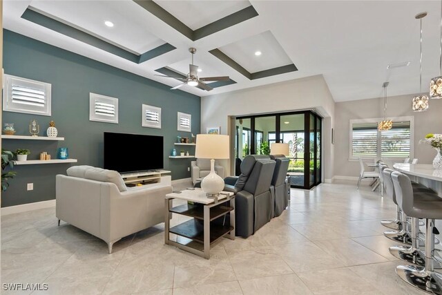 living room featuring ceiling fan with notable chandelier, beam ceiling, and coffered ceiling