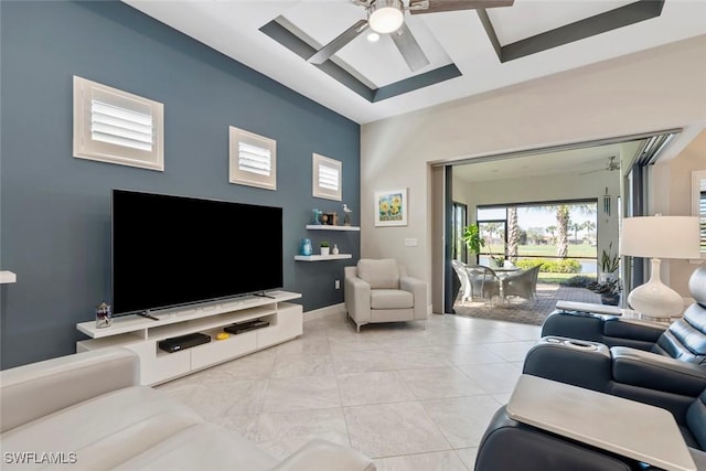 living area featuring light tile patterned floors, a ceiling fan, and baseboards