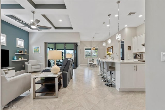 living room featuring visible vents, coffered ceiling, a ceiling fan, beam ceiling, and recessed lighting