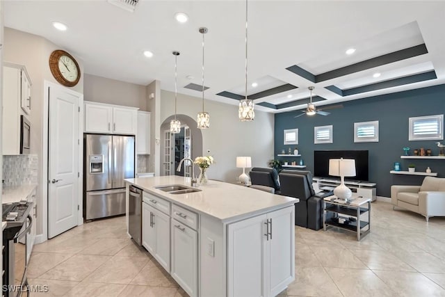 kitchen featuring pendant lighting, a center island with sink, sink, white cabinetry, and stainless steel appliances