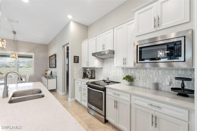 kitchen with stainless steel appliances, white cabinetry, a sink, and under cabinet range hood