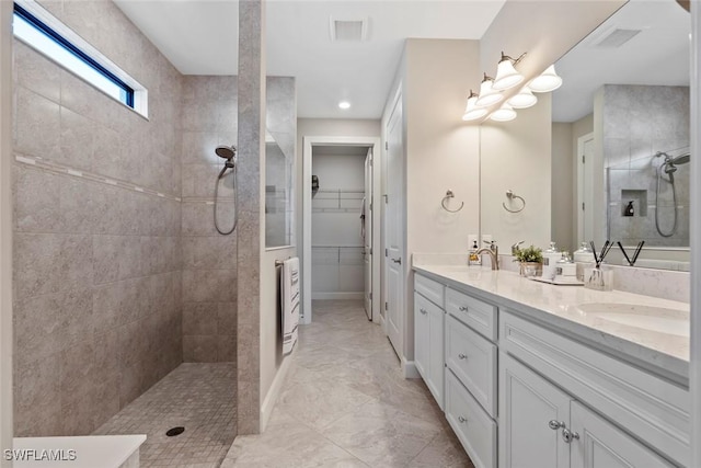 bathroom featuring walk in shower, a sink, visible vents, and double vanity