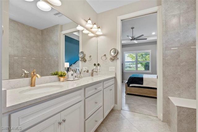 ensuite bathroom featuring a sink, double vanity, tile walls, and ensuite bathroom