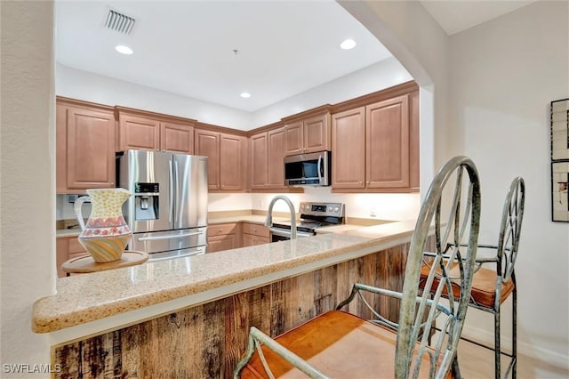 4350 Lazio Way Unit 1102, Fort Myers, FL 33901 - kitchen with stainless steel appliances, light stone countertops, a peninsula, a kitchen bar, and recessed lighting