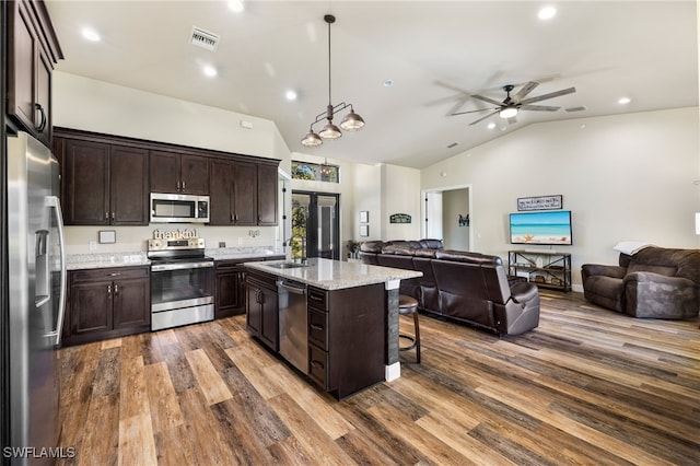 kitchen featuring appliances with stainless steel finishes, dark brown cabinetry, pendant lighting, a center island, and lofted ceiling