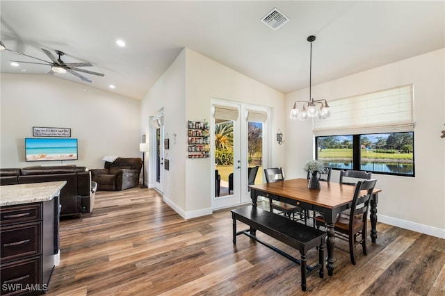 dining area featuring french doors, ceiling fan with notable chandelier, dark hardwood / wood-style floors, and lofted ceiling