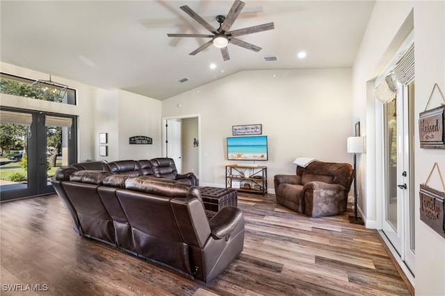 living room with hardwood / wood-style flooring, ceiling fan with notable chandelier, and lofted ceiling