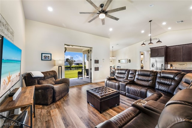 living room featuring ceiling fan, dark wood-type flooring, and vaulted ceiling